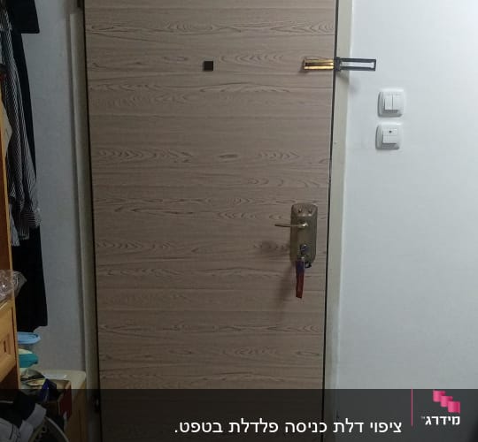 דלת עץ עם ידית מתכת ומנעול